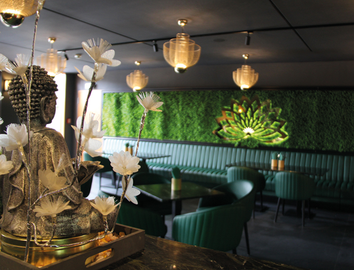 Asiatisches Restaurant in der Therme. Modern Eingerichtet mit bequemen Möbel und Asiatische Dekorationen. Im Hintergrund befindt sich eine Wand mit künstlichem Moos und eine Goldene Lotusblume mit indirekter Belechtung.