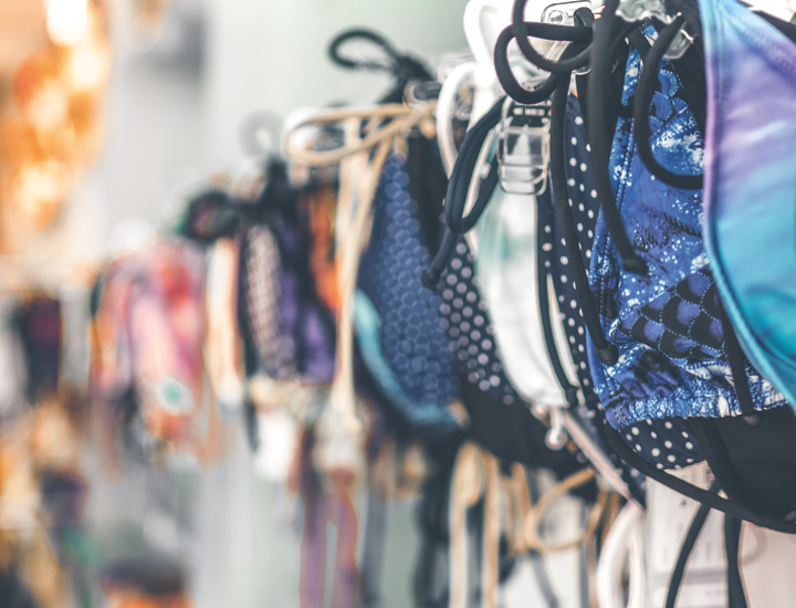 Bunte Bikinis hängend in einer Reihe auf Kleiderbügel. 