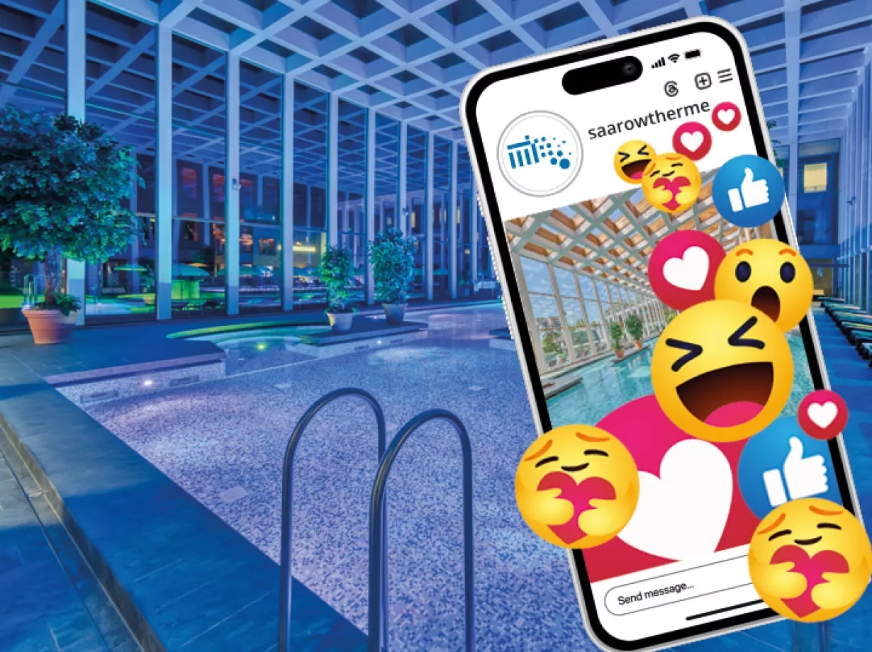 Abbildung des Thermalbades am Abend. Im Thermalbad herrscht eine blau lila Beleuchtung wie zur blauen Stunde, die für eine romantische Stimmung sorgt. Im Vordergrund des Bildes ist ein Smartphone abgebildet mit eine Reihe von Emoji Symbole, die daraus hinweisen, die SaarowTherme bei Social Media zu Folgen.
