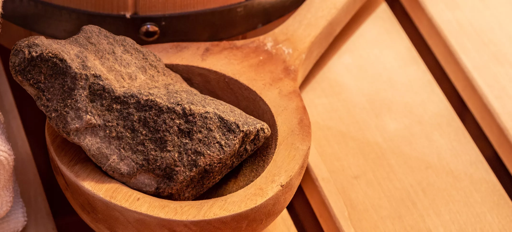 Eine Saunakelle mit einem Saunstein dekorativ abgebildet