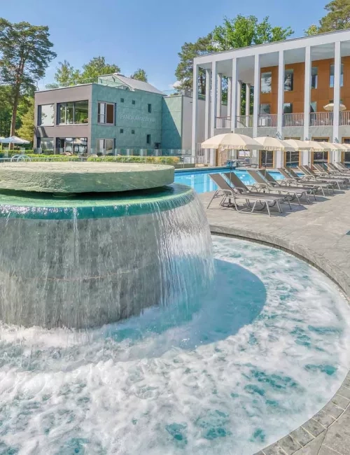Massagepilz mit Strömungskanal im Außenbereich der SaarowTherme. Türkisblauem Wasser, blauer Himmel und Liegen am Beckenrand vermitteln Urlaubsfeeling pur.