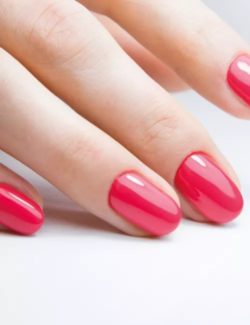 Nahaufnahme einer Hand mit rosa lackierten Fingernägeln.