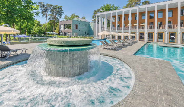 Massagepilz mit Strömungskanal im Außenbereich der SaarowTherme. Türkisblauem Wasser, blauer Himmel und Liegen am Beckenrand vermitteln Urlaubsfeeling pur.