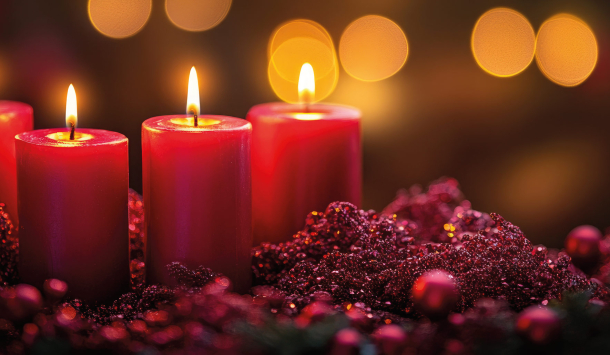 Bild von einem roten Adventskranz mit roten Kerzen. Rote Beeren sind überall auf dem Krank verteilt und rund um den Kranz ebenso. Die Kerzen sind alle an und im Hintergrund funkeln ganz viele Lichter, die eine weihnachtliche Stimmung verbreiten.