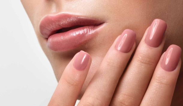 Schön geschminkte Frau hält eine Hand am Gesicht. Die Hand sind gut gepflegt und 