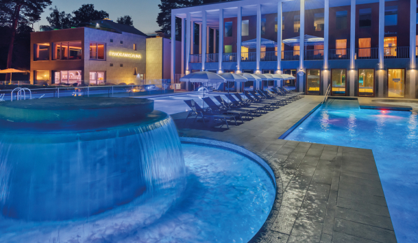 Massagepilz mit Strömungskanal im Außenbereich der SaarowTherme. Türkisblauem Wasser, sternenklarer Nachthimmel und Liegen am Beckenrand vermitteln eine entspannte Abendliche Atmosphäre.