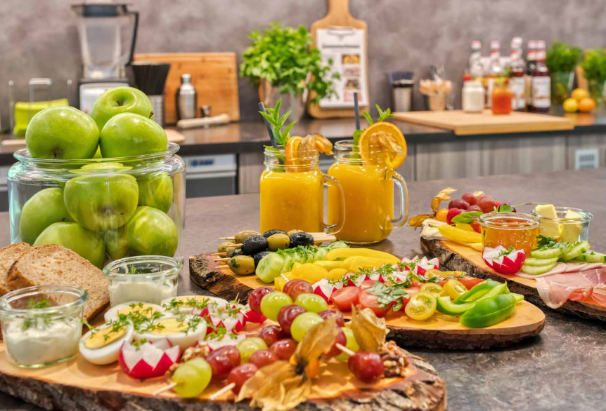 Tresen mit Auslage von Brotzeiteller auf einem Holzbrett präsentiert und Gläser mit Orangesaft mit frischem Obst