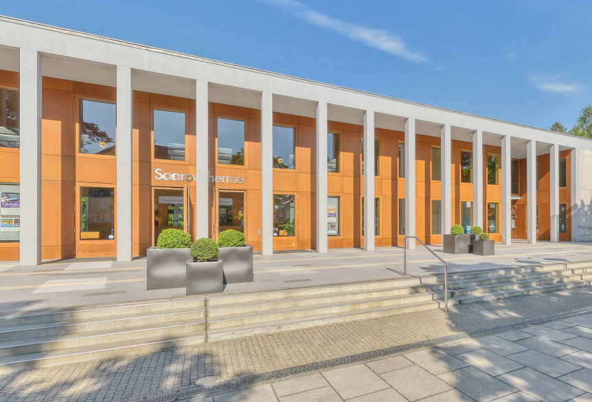 Das Gebäude der SaarowTherme. Mit einer Front von Betonsäulen und einer Holzfassade.