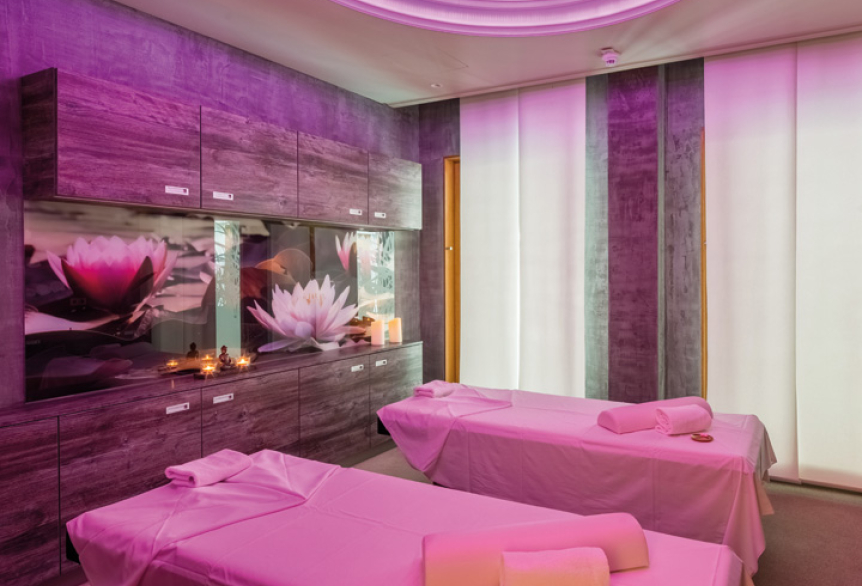 Modernes Wellnesszimmer der SaarowTherme in Rosa, Massagetisch mit Handtüchern