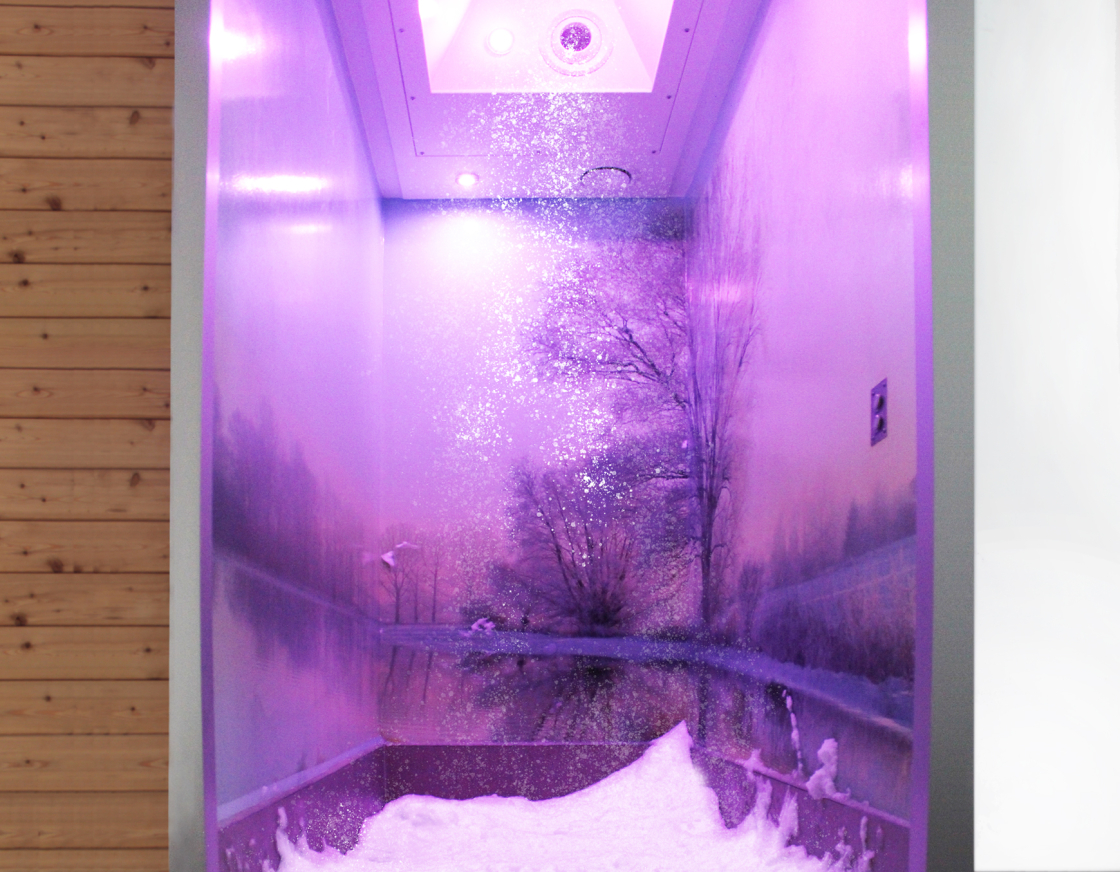 Eine moderne Schneekabine mit lila Beleuchtung. An den Wänden ist Frost zu sehen, der Boden ist mit Schnee bedeckt. 