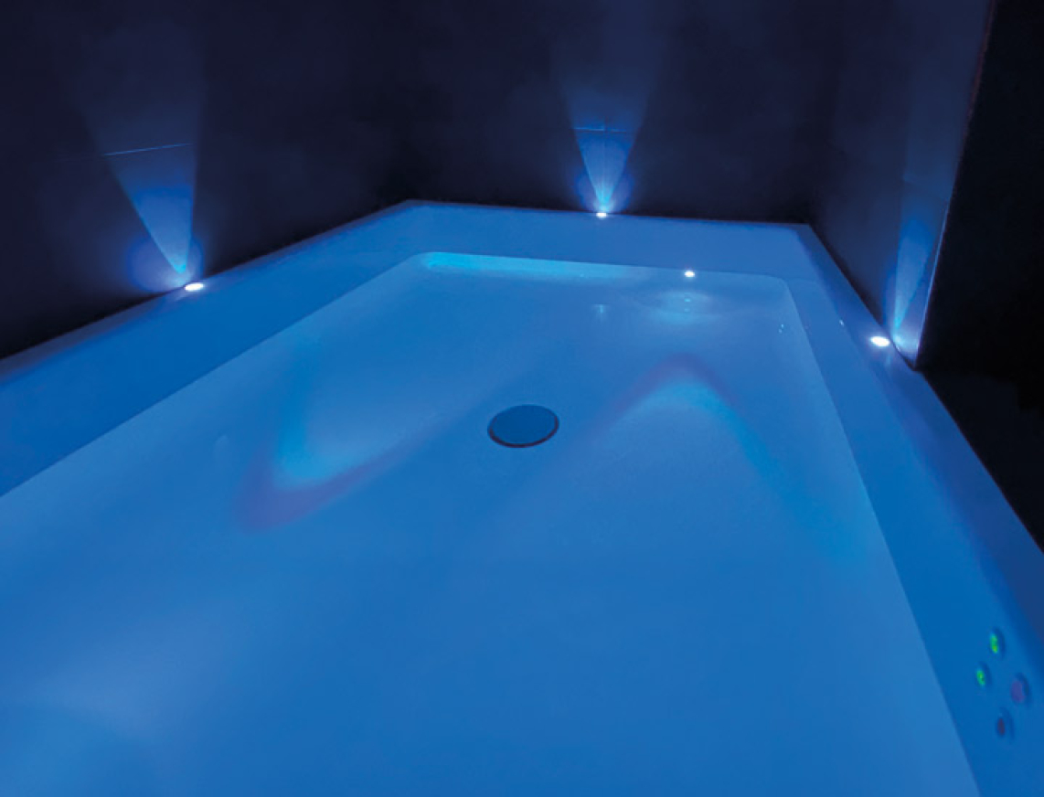 Floatingbecken in einem blaun Licht getaucht. EIne große Wanne mit blauem Licht an der Seite und in der Wanne.