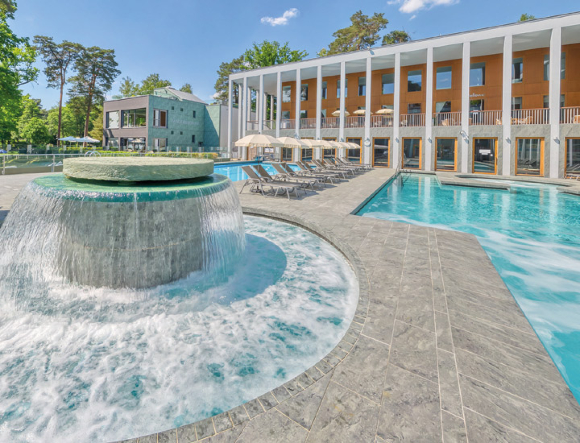 Massagepilz mit Strömungskanal im Außenbereich der SaarowTherme. Türkisblauem Wasser, blauer Himmel und Liegen am Beckenrand vermitteln Urlaubsfeeling pur.